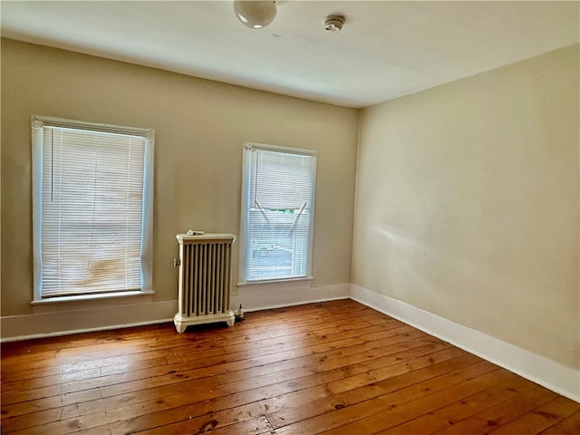 spare room with radiator and hardwood / wood-style floors