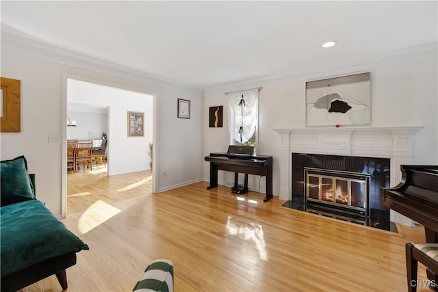 living room with ornamental molding, a tiled fireplace, and hardwood / wood-style flooring