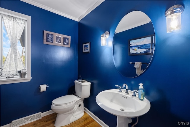 bathroom with hardwood / wood-style floors, ornamental molding, toilet, and sink