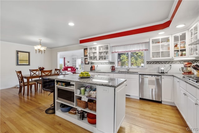 kitchen with white cabinets, light hardwood / wood-style floors, appliances with stainless steel finishes, and sink