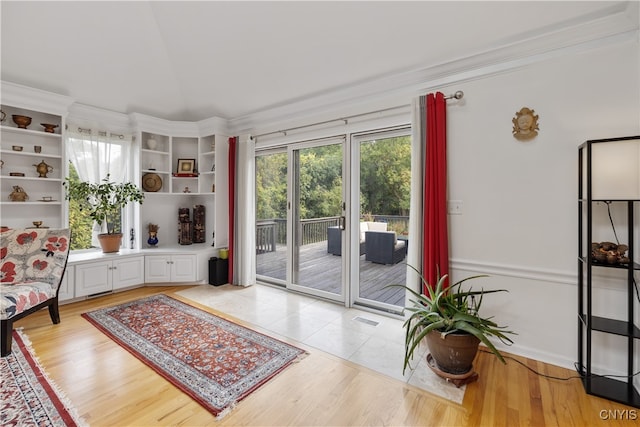 sitting room featuring light hardwood / wood-style flooring and crown molding