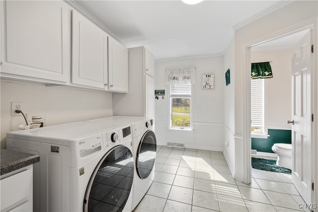 laundry area with crown molding, light tile patterned floors, independent washer and dryer, and cabinets