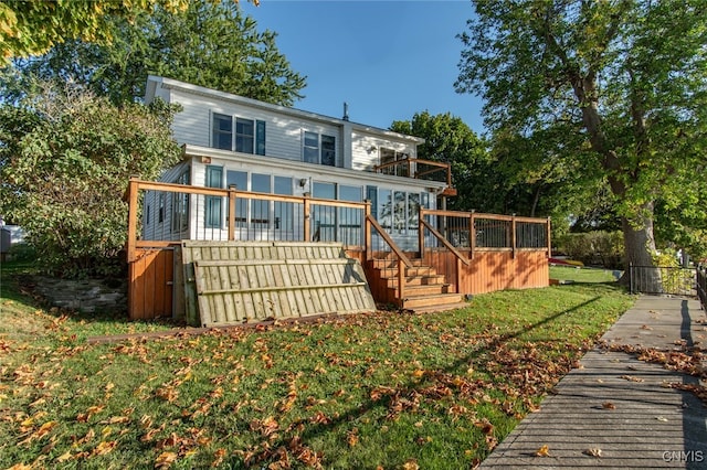 rear view of property with a wooden deck and a yard