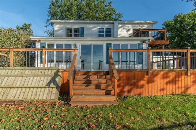 rear view of house with a wooden deck and a sunroom