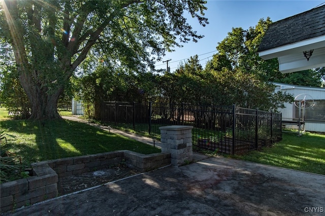 view of gate featuring a patio and a lawn