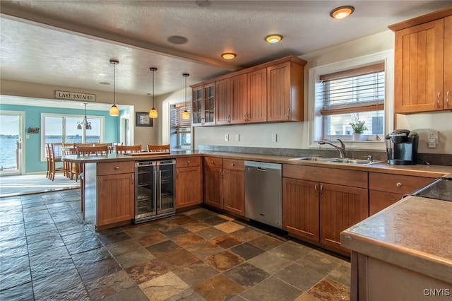 kitchen with a healthy amount of sunlight, sink, stainless steel dishwasher, and beverage cooler