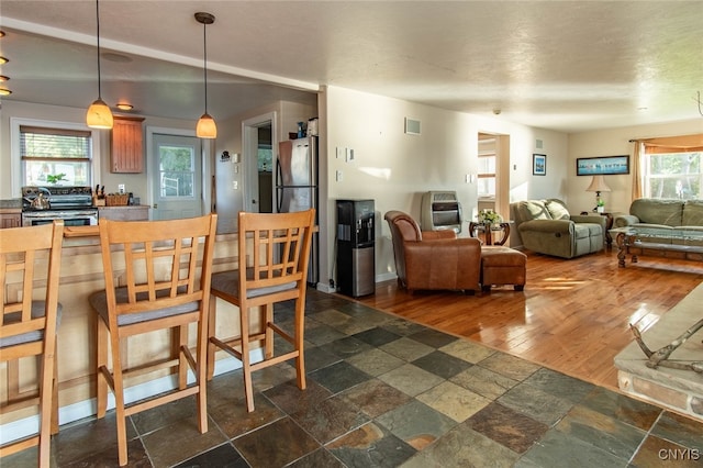 dining room with a healthy amount of sunlight, dark wood-type flooring, and heating unit