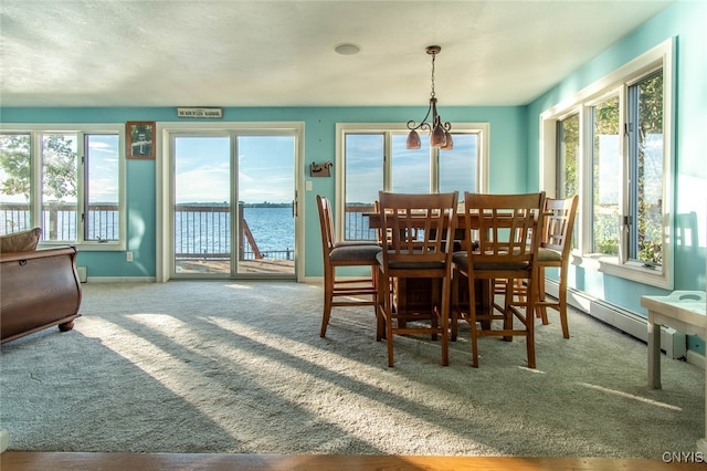 dining space featuring a water view, a wealth of natural light, and a baseboard radiator