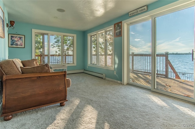 sunroom / solarium with a baseboard heating unit and a water view