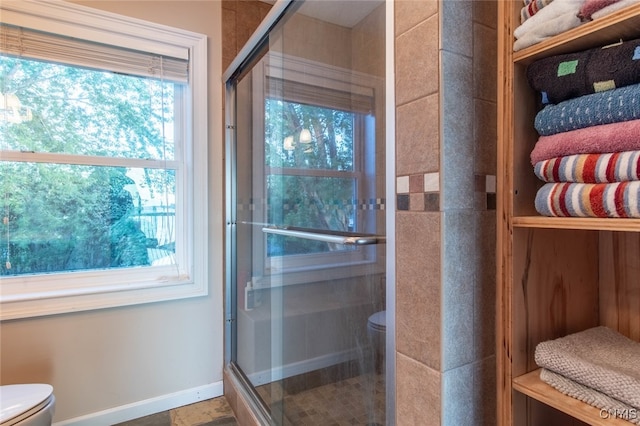 bathroom with toilet and an enclosed shower