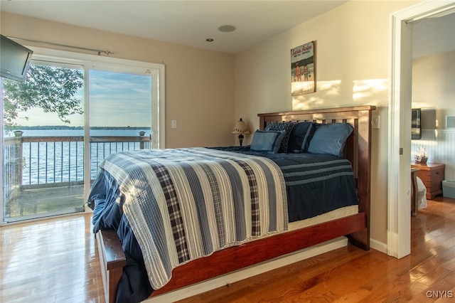 bedroom with access to outside and hardwood / wood-style flooring