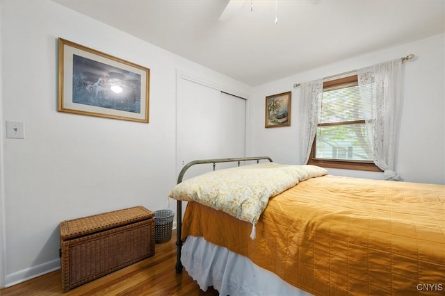 bedroom with a closet, ceiling fan, and dark hardwood / wood-style flooring