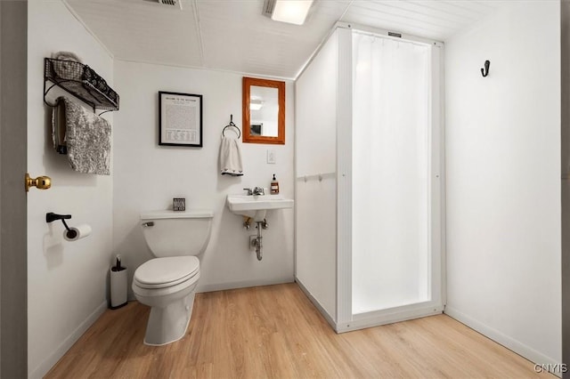 bathroom with toilet, wood-type flooring, and sink