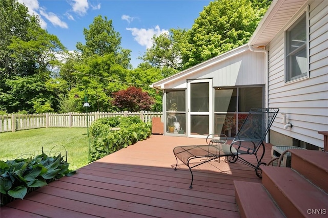 deck featuring a sunroom and a yard