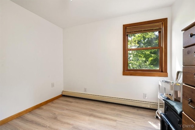 spare room with a baseboard radiator and light hardwood / wood-style floors