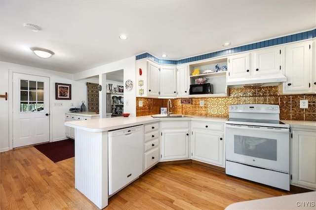 kitchen featuring kitchen peninsula, white appliances, sink, light hardwood / wood-style flooring, and white cabinets