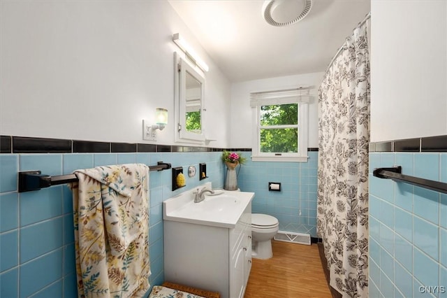 bathroom featuring hardwood / wood-style flooring, vanity, tile walls, and toilet