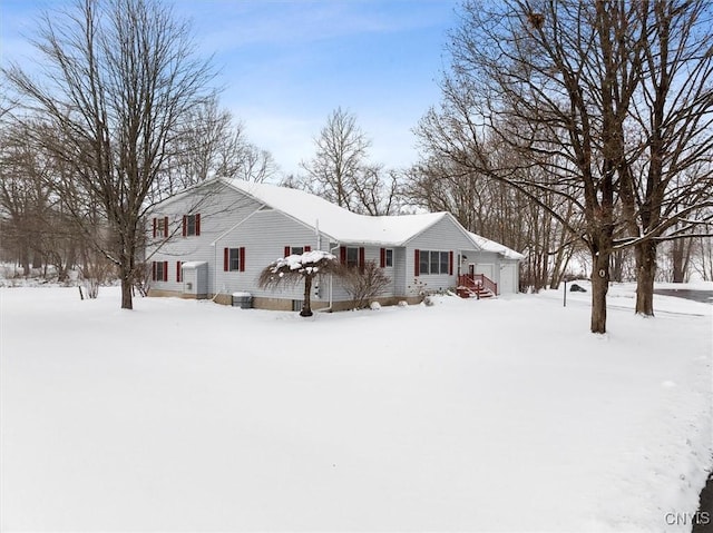 snow covered property with a garage