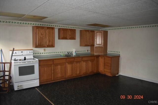 kitchen featuring white electric stove, brown cabinetry, and a sink