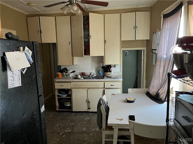 kitchen with backsplash, black refrigerator, ornamental molding, ceiling fan, and cream cabinets