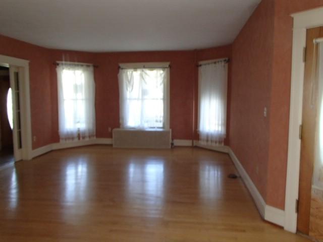 unfurnished living room featuring light wood finished floors and baseboards