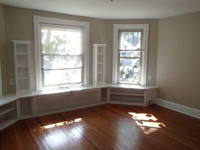unfurnished room with hardwood / wood-style flooring and baseboards