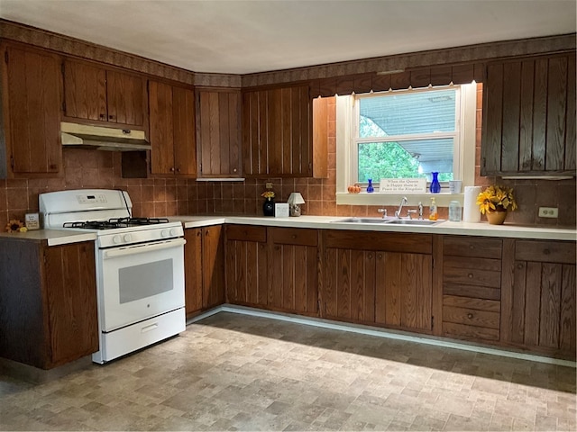 kitchen with backsplash, sink, and white gas range oven