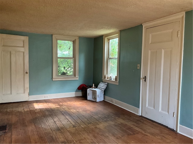 spare room featuring a textured ceiling and wood-type flooring