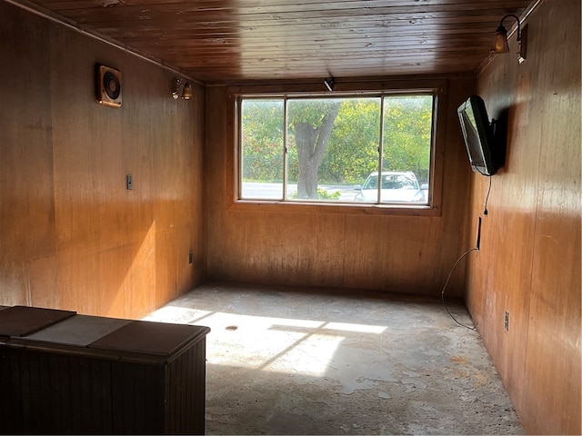 spare room featuring wood ceiling and wooden walls