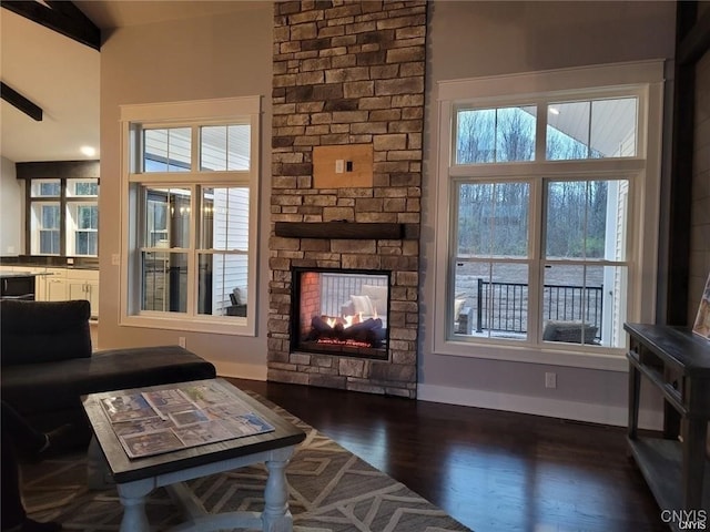 living room with a fireplace, lofted ceiling with beams, and dark hardwood / wood-style flooring