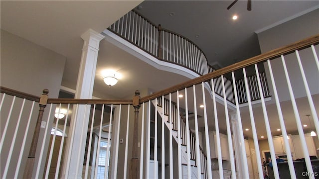 staircase featuring ornamental molding, a towering ceiling, and decorative columns