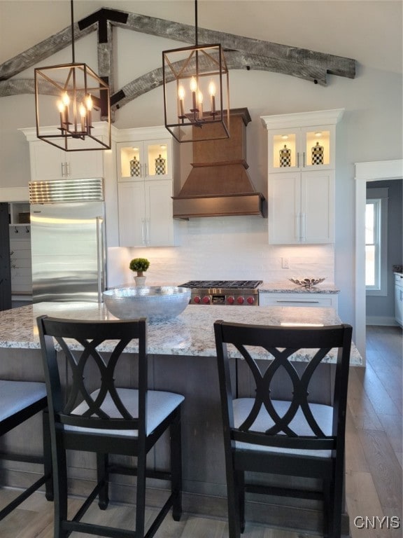 kitchen featuring decorative light fixtures, stainless steel appliances, white cabinets, and light hardwood / wood-style flooring