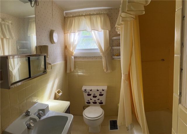 bathroom featuring shower / bathtub combination with curtain, tile walls, tile patterned flooring, and toilet