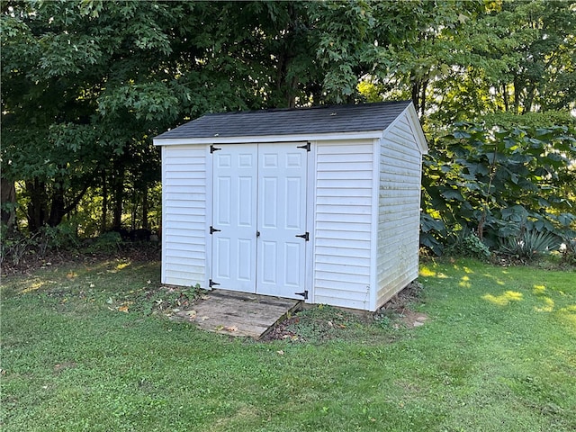 view of outbuilding featuring a lawn