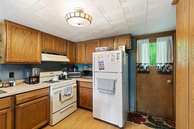 7682 Cottage Rd Unit 2, Wolcott, NY 14590 - kitchen featuring brown cabinets, white appliances, under cabinet range hood, and light wood-style floors