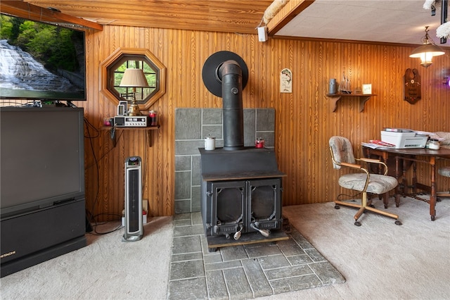 interior space with beam ceiling, wooden walls, and a wood stove