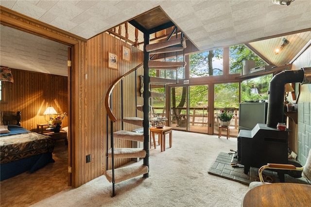 living room with wooden walls, carpet, and lofted ceiling