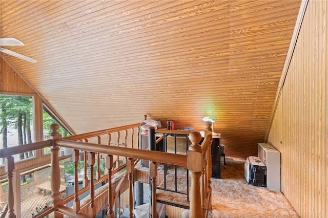 stairs with vaulted ceiling, carpet floors, wood walls, wooden ceiling, and ceiling fan