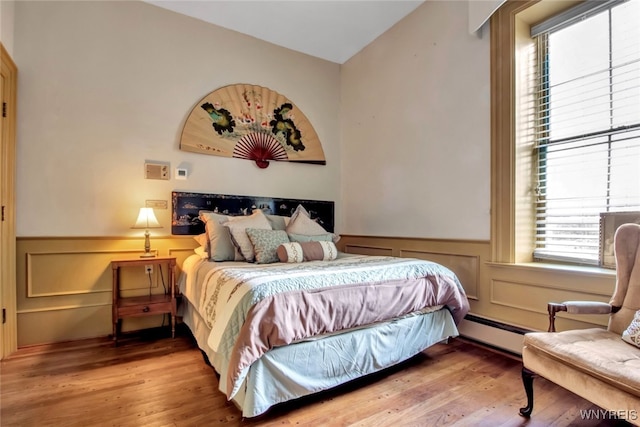 bedroom with hardwood / wood-style flooring and a baseboard radiator