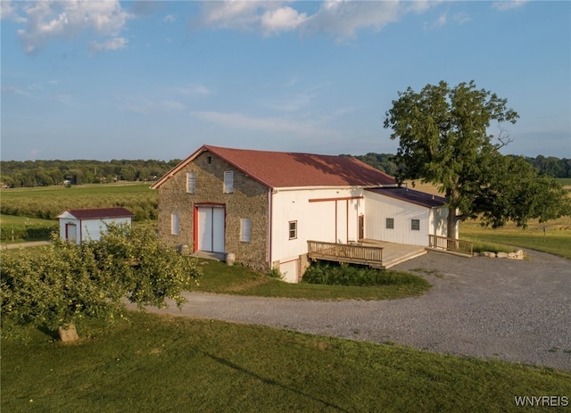 view of front of house featuring a front yard, a storage shed, and a wooden deck