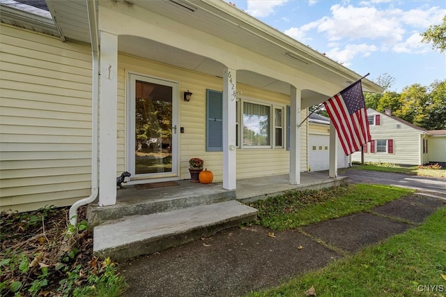 property entrance with covered porch and a garage