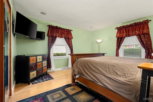 bedroom featuring light hardwood / wood-style flooring and multiple windows