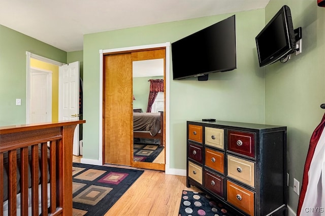 bedroom featuring light wood-type flooring and a nursery area