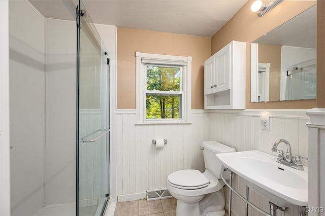 bathroom with sink, toilet, a shower with door, and tile patterned floors