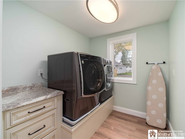 laundry area featuring light hardwood / wood-style flooring and washing machine and clothes dryer