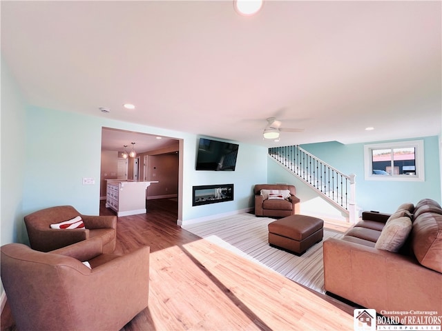 living room with wood-type flooring and ceiling fan