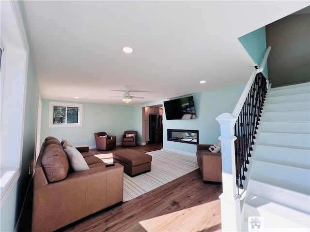 living room featuring light wood-type flooring and ceiling fan