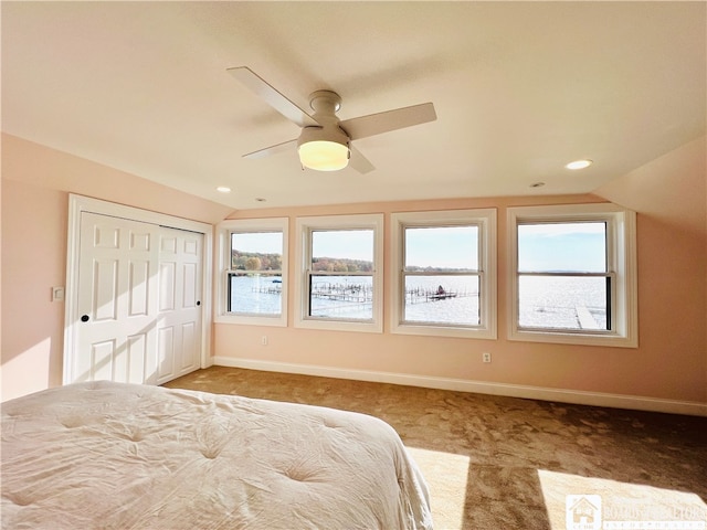 unfurnished bedroom featuring lofted ceiling, multiple windows, and ceiling fan