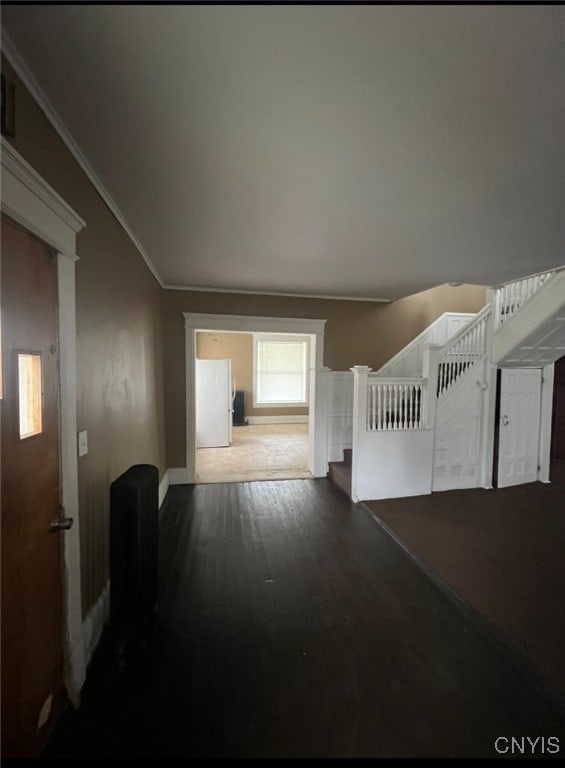 hallway with ornamental molding and hardwood / wood-style floors