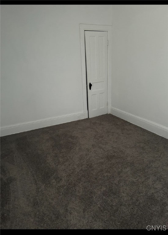 empty room featuring dark carpet